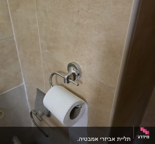 מתקן נייר טואלט מותקן על קיר בחדר אמבטיה